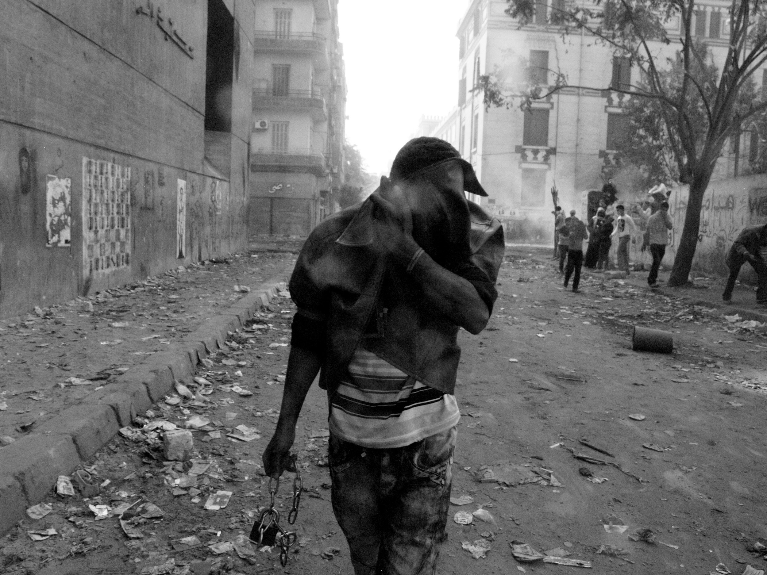 CAIRO.EGYPT.22/11/2011. A man tries to protect themselves from tear gas with the bow jacket in Mohamed Mahmoud st. Protesters during clashes with the Egyptian riot police near Tahrir square in Cairo. Egypt's civilian Cabinet has offered to resign after three days of violent clashes in many cities between demonstrators and security forces, but the action failed to satisfy protesters deeply frustrated with the new military rulers.(GABRIELE MICALIZZI/FOR NYTIMES MAGAZINE)
